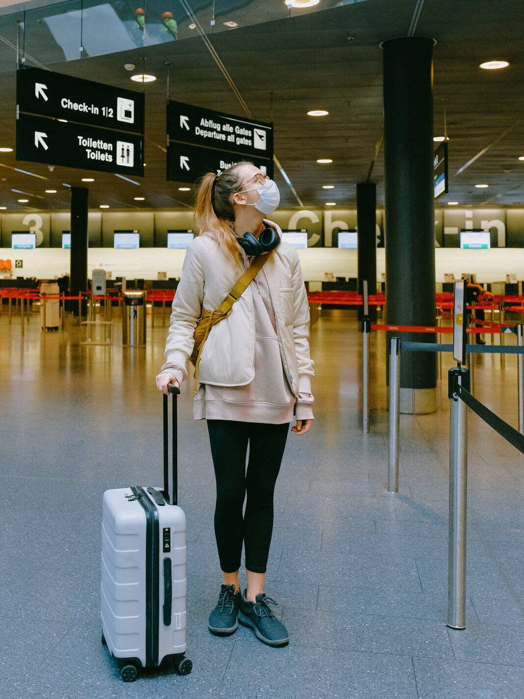 Frau mit Maske vor am Flughafen